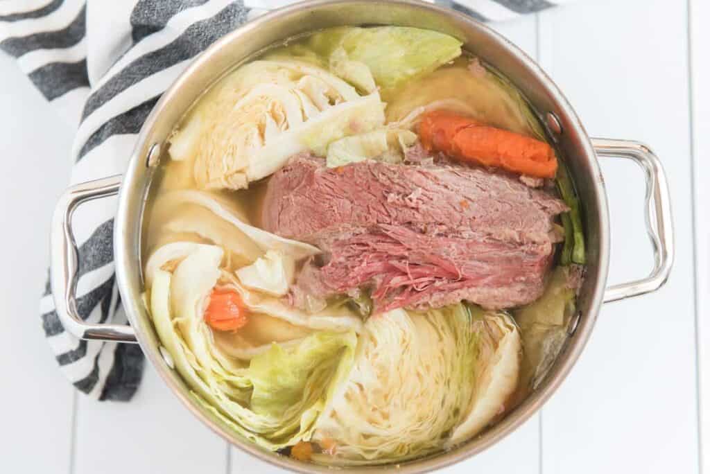corned beef and cabbage with potatoes and carrots in stock pot