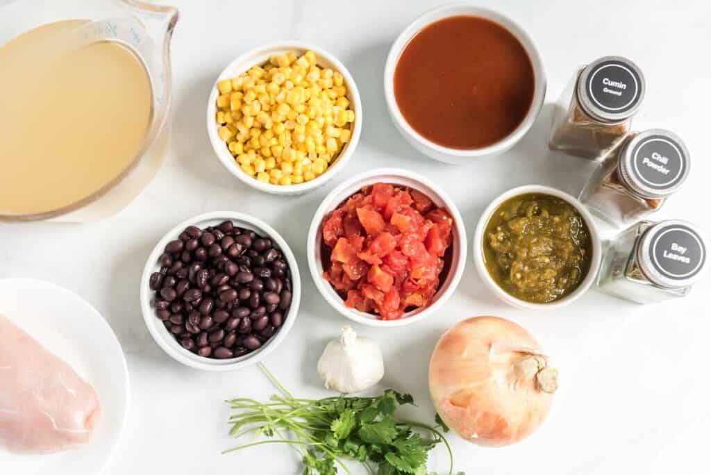 overhead view of chicken tortilla soup ingredients in white bowls 