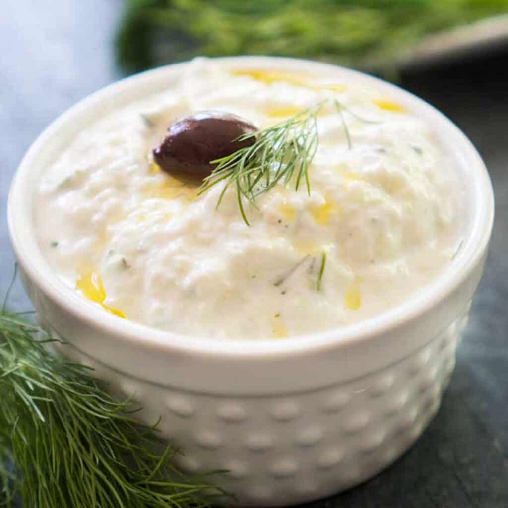 closeup of tzatziki sauce in white hobnail ramekin