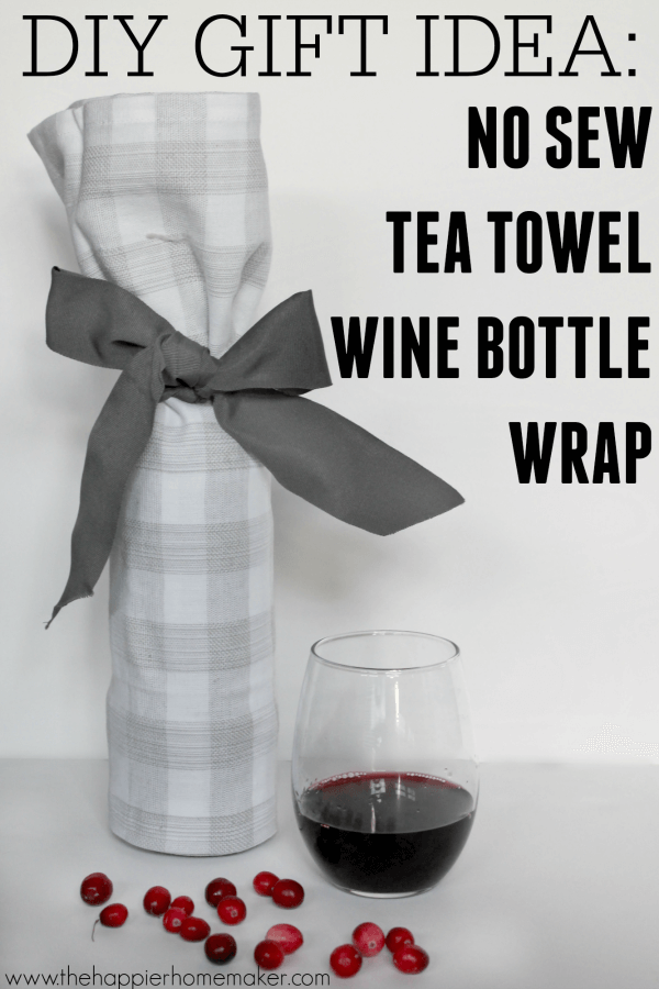 glass of red wine next to a wine bottle wrapped in a tea towel